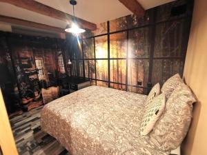 1 dormitorio con 1 cama y una pared con una pintura en Le Vieux Tacot, stationnement gratuit en Le Puy-en-Velay