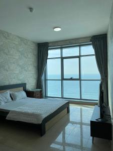 a bedroom with a bed and a large window at Ocean View Luxury Suites in Ajman 