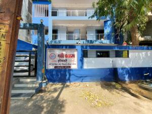 ein blaues Gebäude mit einem Schild davor in der Unterkunft Shridham Homestay in Ujjain