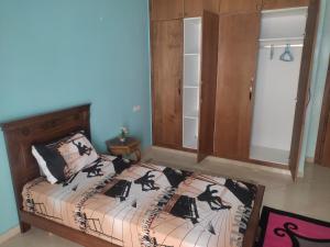ein Schlafzimmer mit einem Bett und einem Schrank in der Unterkunft Appartement 3 in Agadir