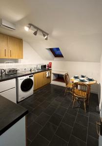 a kitchen with a table and a table and chairs at Firth View, Burghead in Burghead
