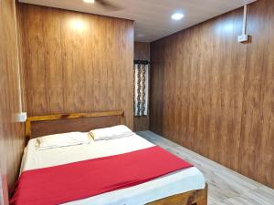 a bedroom with a bed with a wooden wall at Iora Cottages in Alibaug