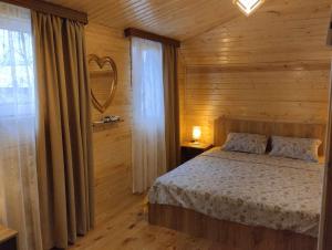 una camera da letto con un letto in una stanza di legno di Guest house number 1 a Batumi Altre 26 foto