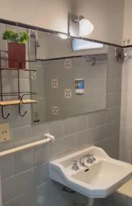 y baño con lavabo blanco y espejo. en Mendoza R km 0 en Mendoza