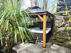 a hot tub in a gazebo in a garden at Aberdunant Hall in Porthmadog