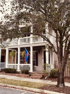 une maison blanche avec un drapeau devant elle dans l'établissement GREAT3Bed&3bath. 2balconies. Perfect Gainesville neighborhood, à West Hills