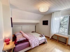 a bedroom with a bed with pink blankets and a window at Grand appartement Les Peintures in Thonon-les-Bains