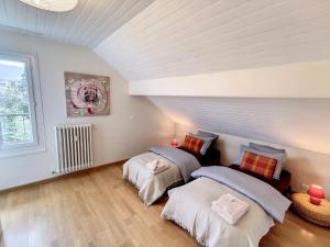 a room with two beds and a window at Grand appartement Les Peintures in Thonon-les-Bains