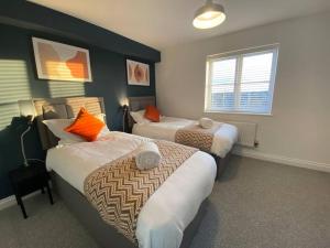 a hotel room with two beds and a window at Stylish 3-Bed House with Free Parking & Netflix by HP Accommodation in Northampton