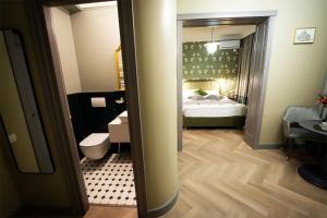 a bathroom with a bedroom with a bed and a toilet at Tempus in Bucharest