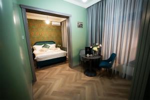 a bedroom with a bed and a table and a chair at Tempus in Bucharest