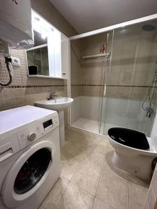 een badkamer met een wasmachine en een wastafel bij Roses Espagne 4/5 pers piscine - plage in Roses