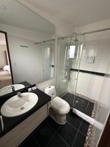 a bathroom with a sink and a toilet and a shower at PERUGINO´S HOTEL GALERIA in Popayan +80 photos
