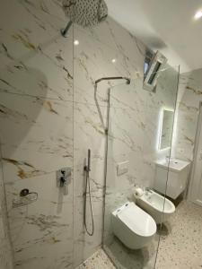 a bathroom with a shower and a toilet and a sink at Tirana Center Apartaments in Tirana