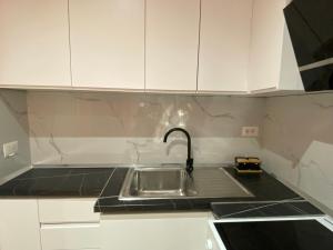 a kitchen with a sink and white cabinets at Tirana Center Apartaments in Tirana