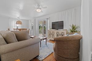 een woonkamer met 2 stoelen en een televisie bij Selah Cottage in Gulf Shores