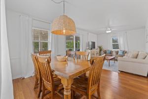 een eetkamer en een woonkamer met een tafel en stoelen bij Selah Cottage in Gulf Shores