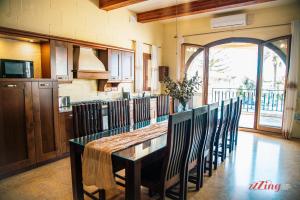 cocina con mesa larga y sillas en una habitación en Gozo Dream with Indoor Pool and an Outdoor Pool, en Għarb