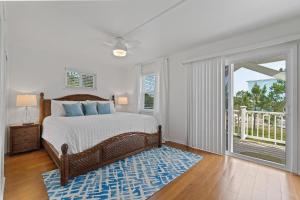 een slaapkamer met een bed en een balkon bij Selah Cottage in Gulf Shores