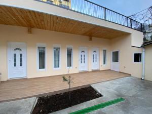 a large house with a wooden porch and white doors at Tirana Center Apartaments in Tirana