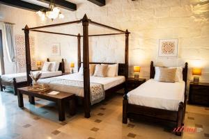 a bedroom with two beds and a table with lamps at Gozo Dream with Heated Indoor Pool and an Outdoor Pool in Għarb