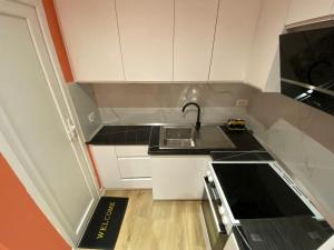 a small kitchen with white cabinets and a sink at Tirana Center Apartaments in Tirana