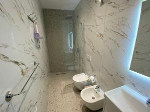 a bathroom with a toilet and a shower and a sink at Tirana Center Apartaments in Tirana