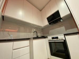 a kitchen with white cabinets and a sink and a stove at Tirana Center Apartaments in Tirana