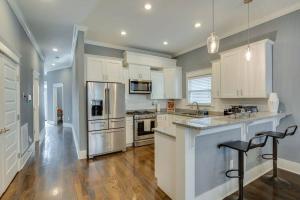a large kitchen with white cabinets and stainless steel appliances at NEW 7 mins to Broadway Sleeps 8 in Nashville