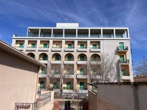 un alto edificio bianco con molte finestre sopra di Hotel La Margherita & SPA ad Alghero