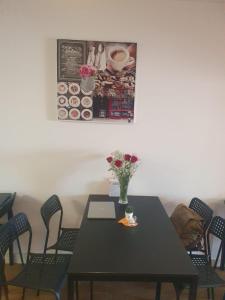 a black table with chairs and a vase of flowers on it at Hostel Vasco Da Gama in Lagos