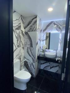 y baño con aseo, lavabo y espejo. en The Rock Hostel en Ponta Delgada