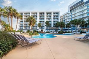 een resort met stoelen en een zwembad en een gebouw bij GS Surf & Racquet 516A in Gulf Shores