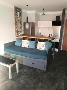 un sofá en una habitación con una mesa y un banco en Apartamenty Sielawa, en Mikołajki