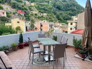 a patio with a table and chairs on a balcony at Keteia - Amalfi Coast in Cetara