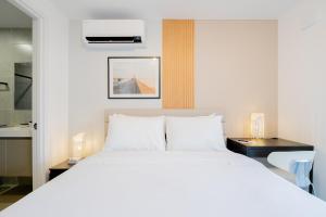 a bedroom with a large white bed with two night stands at Wynwood House San Francisco in Panama City