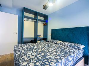 a bedroom with a bed with a blue wall at Apartamentos Nirvana y Averno in Águilas