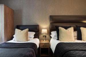 um quarto de hotel com duas camas com almofadas em Stone Villa Chester em Chester