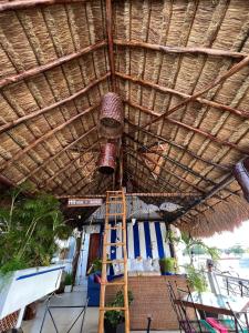 een gebouw met een rieten dak en een ladder eronder bij Hostelito Hotel in Cozumel