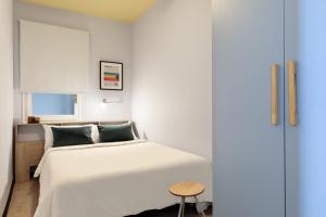una camera con un letto bianco e un tavolo di Maria Poblenou Apartment by Olala Homes a Barcellona