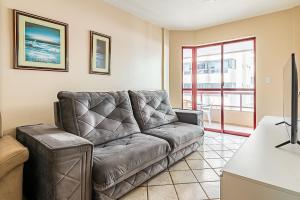 - un salon avec un canapé en cuir et une table dans l'établissement Apto pé na areia vista mar em Meia Praia EVB308, à Itapema