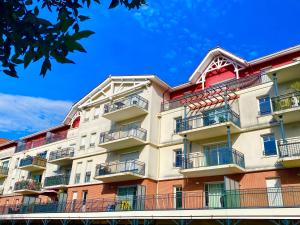 an apartment building with balconies and a blue sky at CAPTAL beau 2 pièces cœur de ville parking terrasse in La Teste-de-Buch