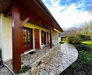 een huis met een stenen loopbrug ervoor bij Maison dans la forêt in Gujan-Mestras