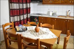 a kitchen with a table with a vase on it at Little House in Mouzaki