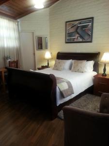 a bedroom with a large bed and a couch at Somona Guest House in Johannesburg