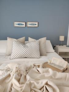 a white bed with a blanket and a book on it at Appartamenti Vacanze Villa Meo in Villafranca Tirrena