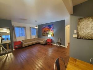 een woonkamer met een bank en een schilderij aan de muur bij 375$/Week // Room B // Full Kitchen in Montreal