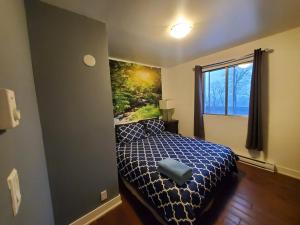 een slaapkamer met een bed en een schilderij aan de muur bij 375$/Week // Room B // Full Kitchen in Montreal