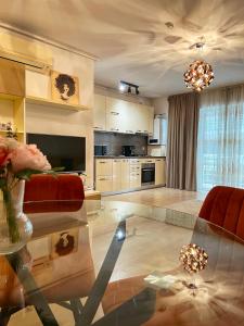 sala de estar con mesa de cristal y cocina en Wonderful Park Residences 5, en Bucarest