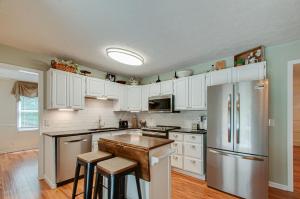 una cucina con armadi bianchi e frigorifero in acciaio inossidabile di NEW Secluded Pool Home 20 Mins to DWTN a Bellevue
